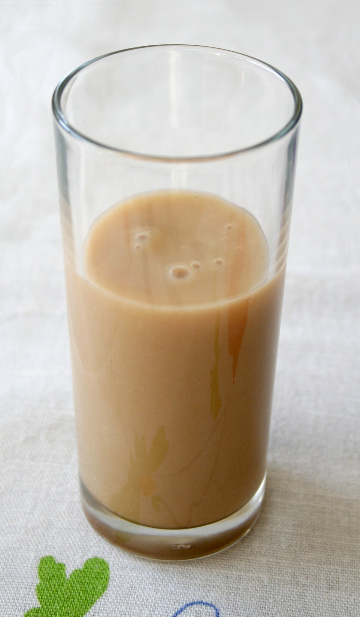 Üzerinde tarçın ve leblebi olan bir bardak Boza